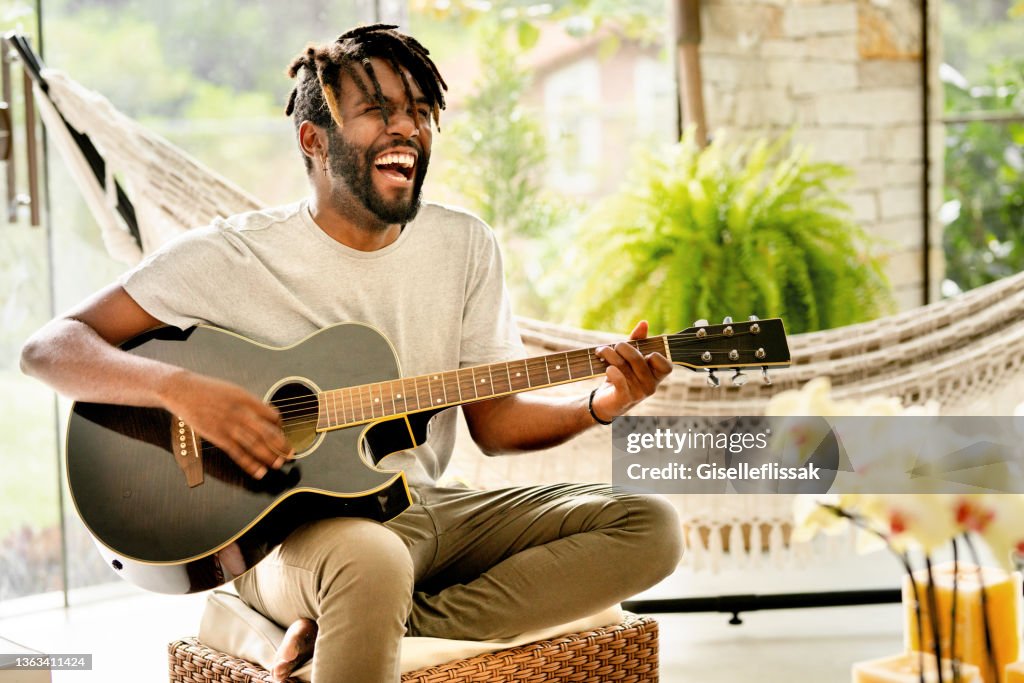 Jovem sorridente tocando violão