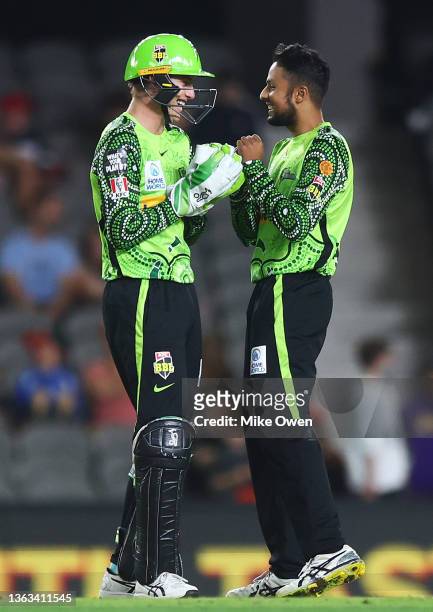 Tanveer Sangha celebrates with teammate Baxter Holt after dismissing Josh Lalor of the Renegades during the Men's Big Bash League match between the...