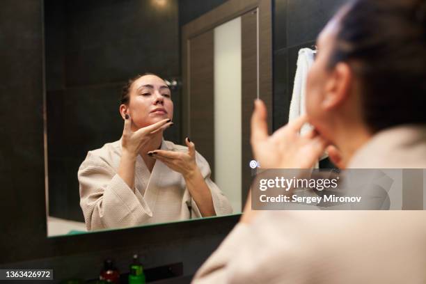 female massaging face in front of mirror - haka bildbanksfoton och bilder