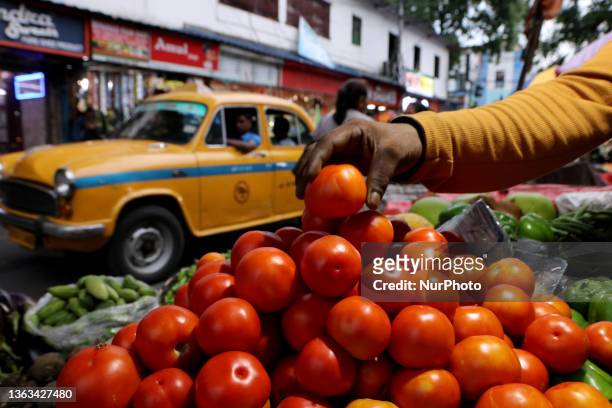 Indian Seller displaying Tomato and waiting for customer,The vegetable daily market in Kolkata,India on June 30,2023.Vegetable prices across the...