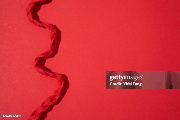 red rope on plain background with copy space - stringa foto e immagini stock