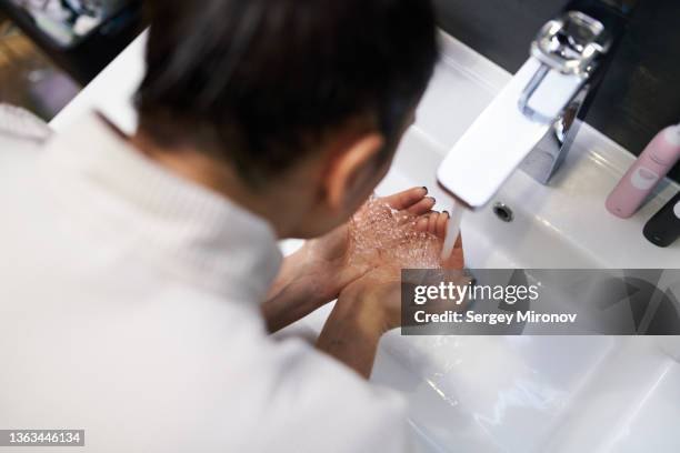woman washing face with soap - gesichtsreinigung stock-fotos und bilder