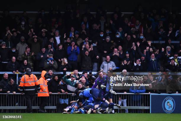 Joe Jacobson of Wycombe Wanderers is bundled on by Adebayo Akinfenwa and teammates as he celebrates scoring their team's third goal during the Sky...