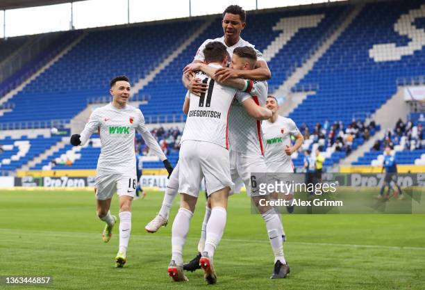 Michael Gregoritsch of FC Augsburg celebrates with teammates Jeffrey Gouweleeuw and Felix Uduokhai after scoring their team's first goal during the...
