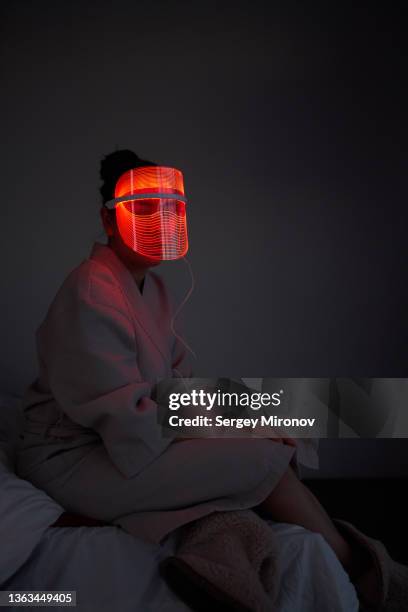 female in led facial mask - luce led foto e immagini stock