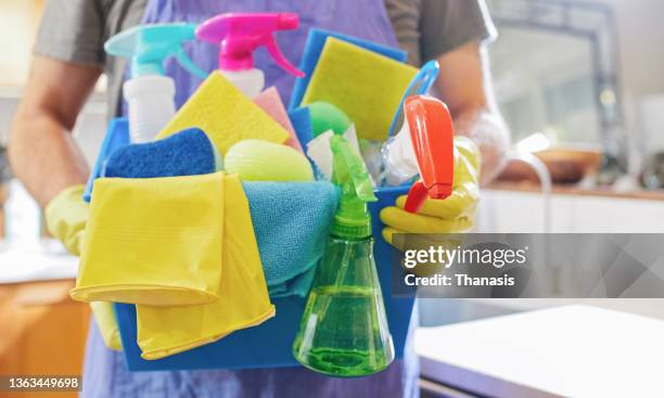 a house cleaner holding cleaning and sanitizing utilities for kitchen worktop and surfaces cleaning - janitorial services bildbanksfoton och bilder