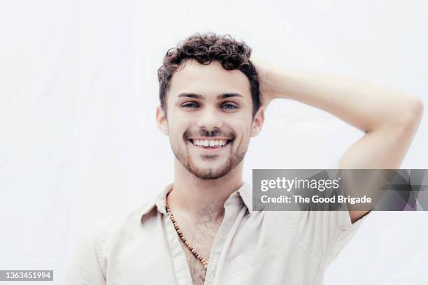 handsome man with hand in hair against white background - goatee stockfoto's en -beelden