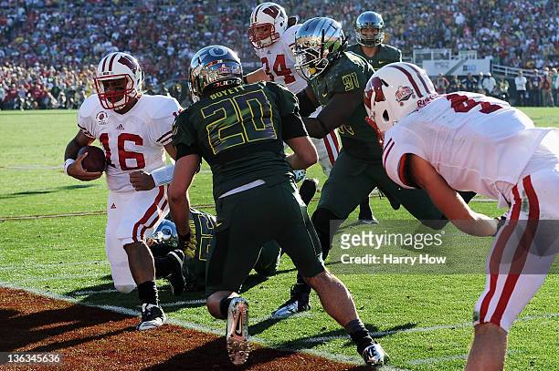 Quarterback Russell Wilson of the Wisconsin Badgers is knocked out of bounds in the second quarter against the Oregon Ducks at the 98th Rose Bowl...