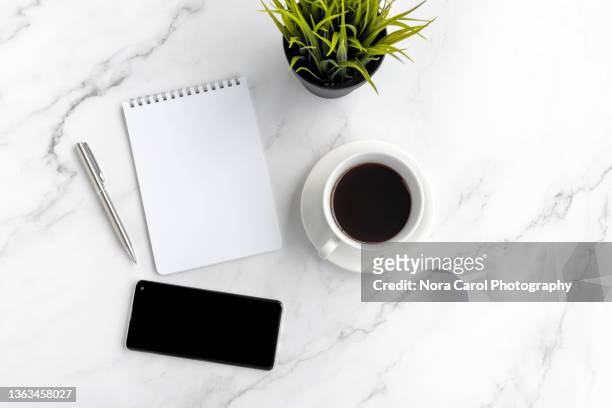 note pad with coffee and a smart phone - notepad table stockfoto's en -beelden