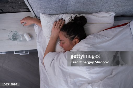 Brunette sleeping in modern bedroom Brunette sleeping in modern bedroom