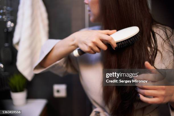 female brushing hair in bathroom - brushing hair stock-fotos und bilder