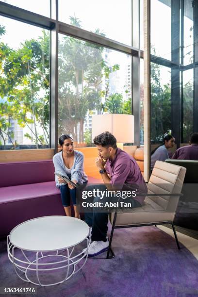 indian woman mentors colleague using tablet stock photo - obama meets with minister mentor of singapore stockfoto's en -beelden