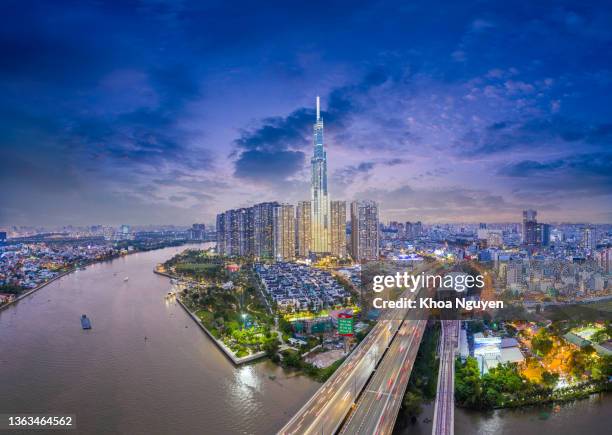 aerial sunset view at landmark 81 - it is a super tall skyscraper and saigon bridge with development buildings along saigon river light smooth down - hochi minh stock pictures, royalty-free photos & images