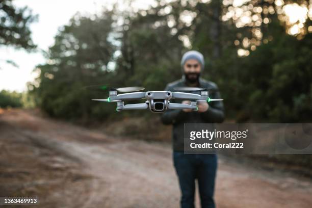 man pilot is flying drone with remote control - remote controlled 個照片及圖片檔