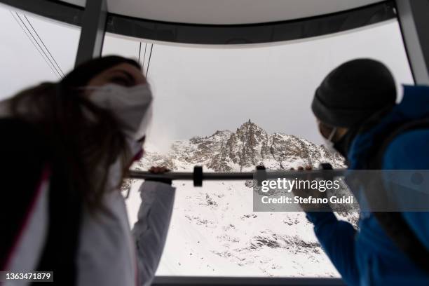 People inside a cable car look out as they visit the Skyway Monte Bianco Cable Car on January 8, 2022 in Courmayeur, Italy. The Skyway Monte Bianco...