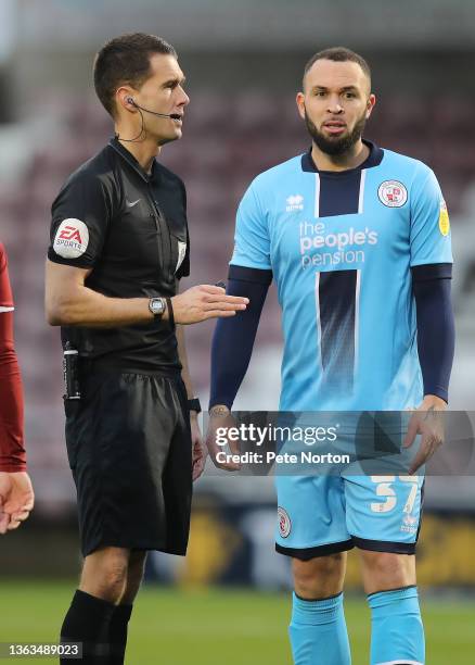 Referee Declan Bourne talks to Joel Lynch of Crawley Town during the Sky Bet League Two match between Northampton Town and Crawley Town at Sixfields...