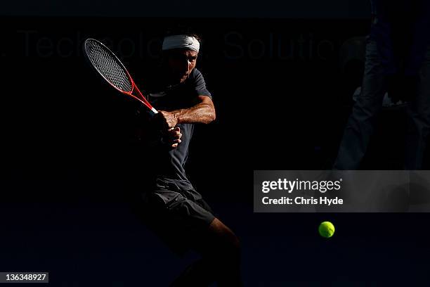 Marinko Matosevic of Australia plays a shot against Tommy Hass of Germany during day three of the 2012 Brisbane International at Pat Rafter Arena on...