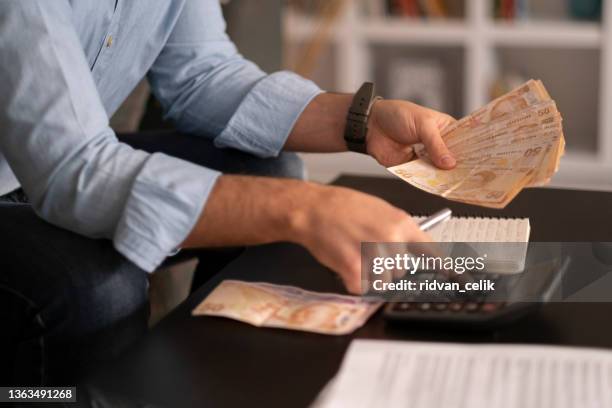 person, die türkische banknoten zählt - geld stock-fotos und bilder