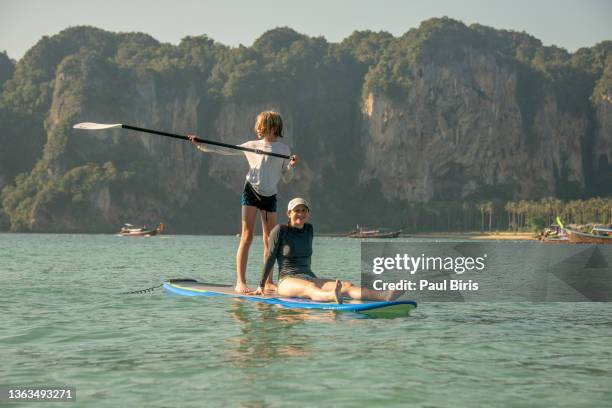 mother and son playing on sup paddleboard, railay beach, ao nang, krabi, thailand - a teen thai stock pictures, royalty-free photos & images