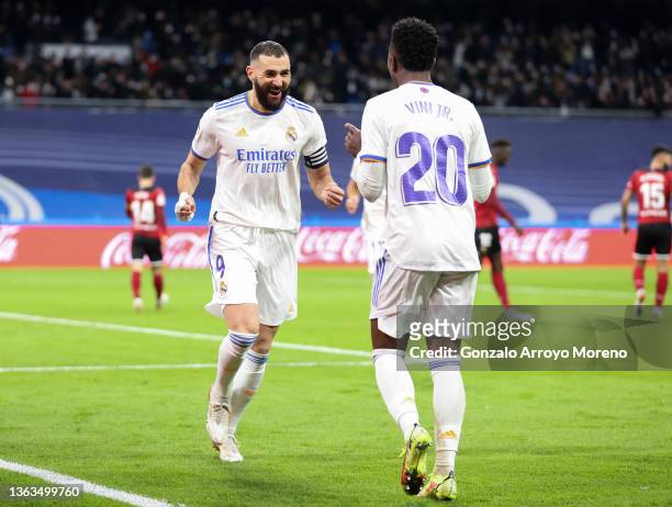 Vinicius Jr of Real Madrid CF celebrates with his team mate Karim Benzema after scoring his team's second goal during the La Liga Santader match...