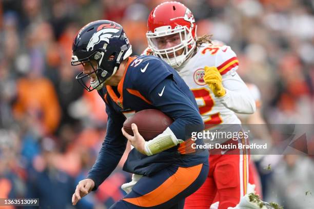 Drew Lock of the Denver Broncos rushes for a touchdown during the second quarter ahead of defender Tyrann Mathieu of the Kansas City Chiefs at...