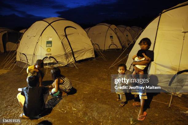 Flood hit residents stand outside tents in a tent city set up by officials on January 3, 2012 in Cagayan de Oro, Mindanao, Philippines. Philippines...