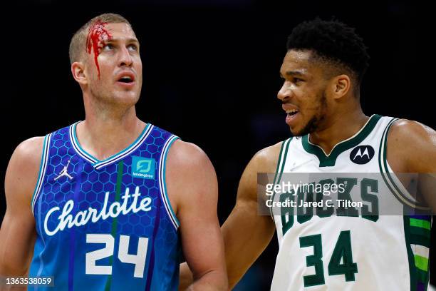 Mason Plumlee of the Charlotte Hornets is met by Giannis Antetokounmpo of the Milwaukee Bucks following an unintentional elbow during the fourth...