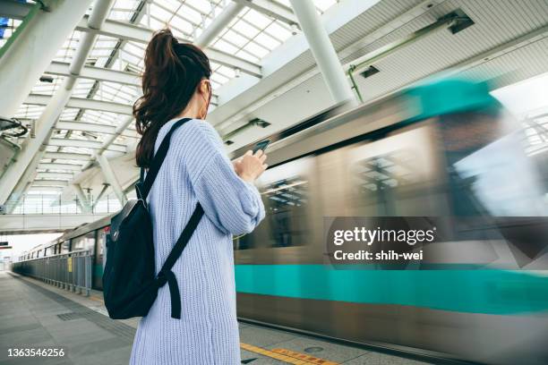 empresaria asiática lleva el mrt al trabajo - andén de estación de metro fotografías e imágenes de stock