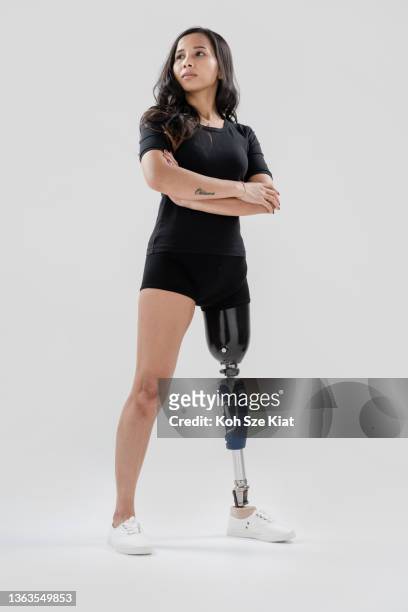portrait of a strong female with a prosthetic leg - strength confidence woman studio stockfoto's en -beelden