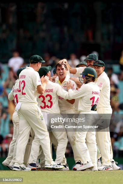 Pat Cummins of Australia celebrates with his team after claiming the wicket of Jos Buttler of England during day five of the Fourth Test Match in the...