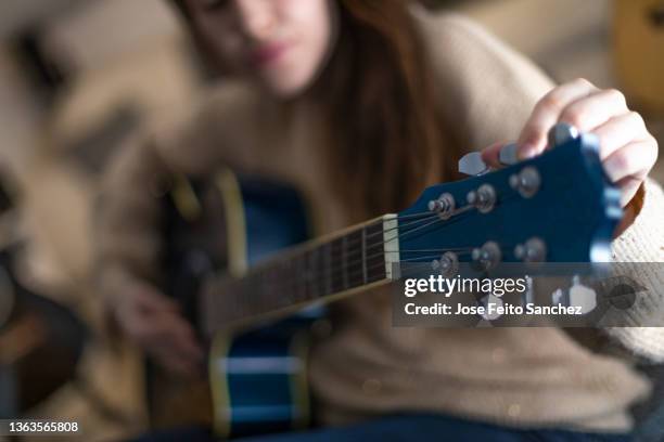 woman's hands playing acoustic guitar, closeup - instrumento de cuerdas fotografías e imágenes de stock