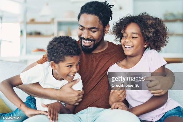 vater hält seine kinder - african american dad stock-fotos und bilder