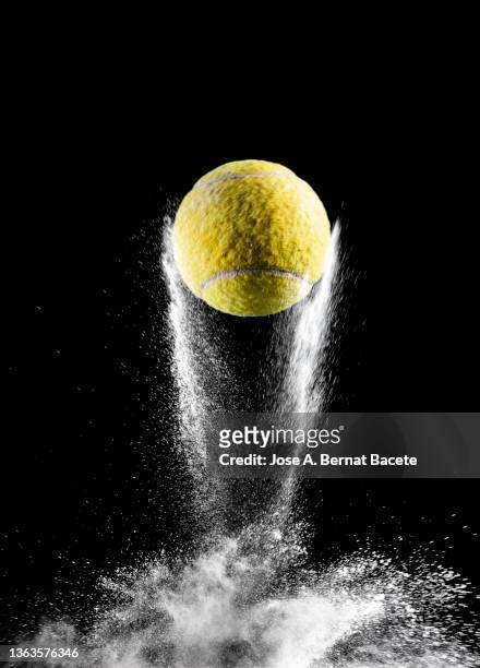 impact and rebound of a ball of tennis on a surface of land and powder on a black background - tennis quick stock pictures, royalty-free photos & images
