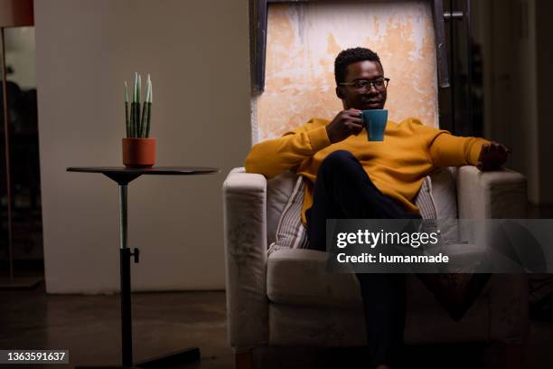 portrait of a young african american man relaxing at home - african ethnicity luxury stock pictures, royalty-free photos & images