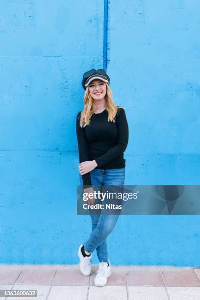 full body smiling blonde woman raising one arm on colorful background outdoors - man standing full body stock-fotos und bilder