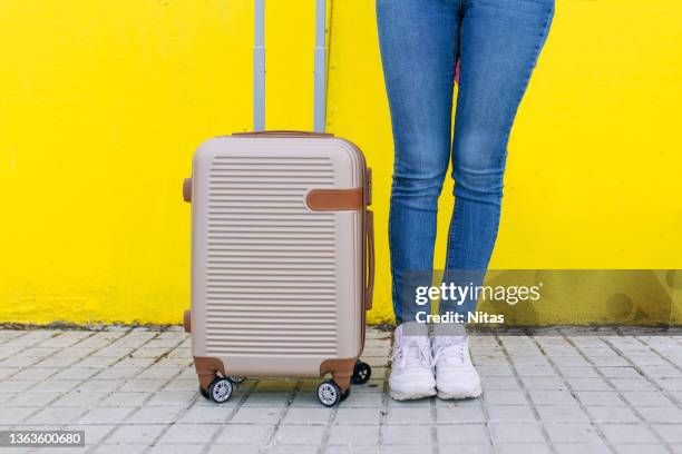 full body blonde woman with mask walking with a trolley bag on color background outdoors - vacances plage stock-fotos und bilder