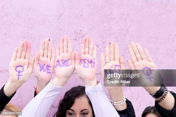 three young females claiming their rights as women on women's day. we are feminist writing in hands. - viollet creative selects stock pictures, royalty-free photos & images