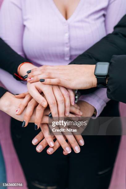 hands of women united supporting each other - feminismo fotografías e imágenes de stock