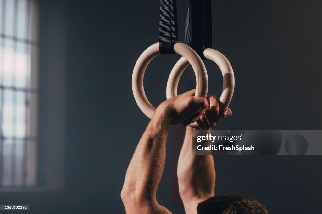 体操リングで運動する男の手のクローズアップ写真