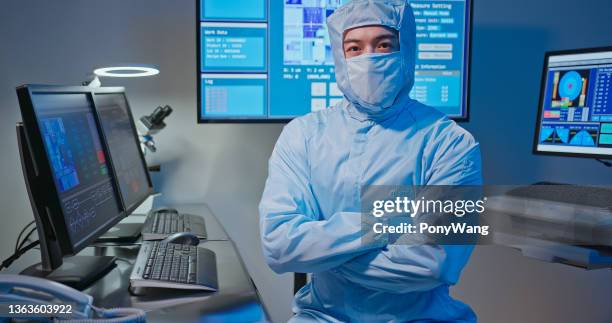 technician in sterile coverall - sala limpa imagens e fotografias de stock