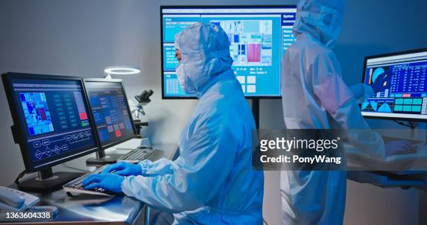 technician in sterile coverall - cleanroom stock pictures, royalty-free photos & images