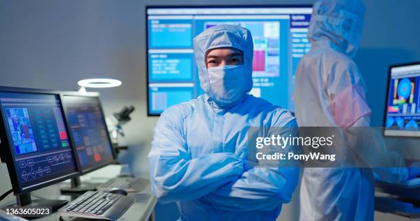 technician in sterile coverall - semiconductors stock pictures, royalty-free photos & images