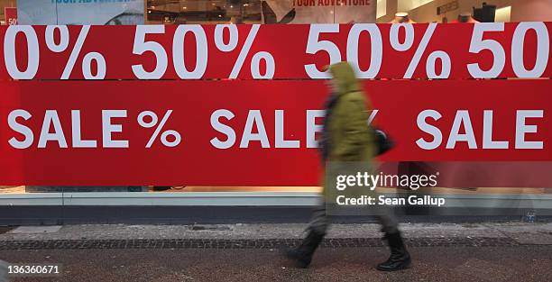 Woman walks past a store advertising sales on January 3, 2012 in Berlin, Germany. Many German retailers are offering heavy discounts in the weeks...
