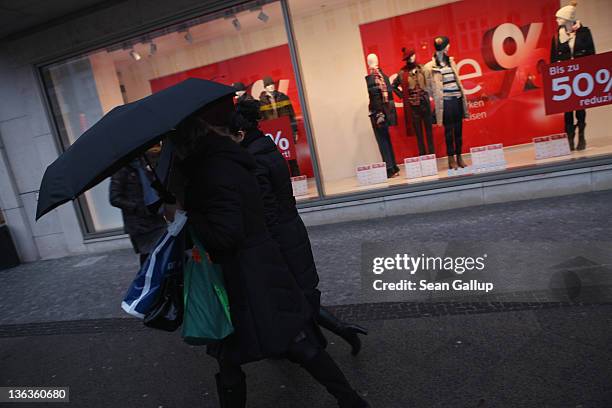 People walk past a store advertising sales on January 3, 2012 in Berlin, Germany. Many German retailers are offering heavy discounts in the weeks...