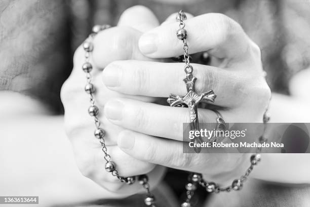 praying hands with rosary - rosary beads fotografías e imágenes de stock