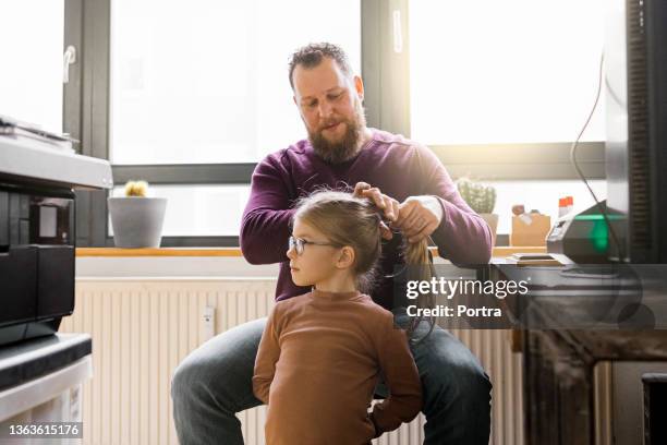 man working at home and making a ponytail to his daughter - brushing hair stock pictures, royalty-free photos & images