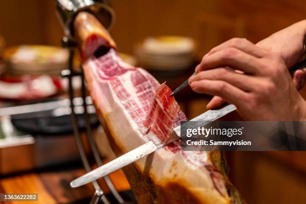 close-up of chef cutting spanish ham - serrano-schinken stock-fotos und bilder