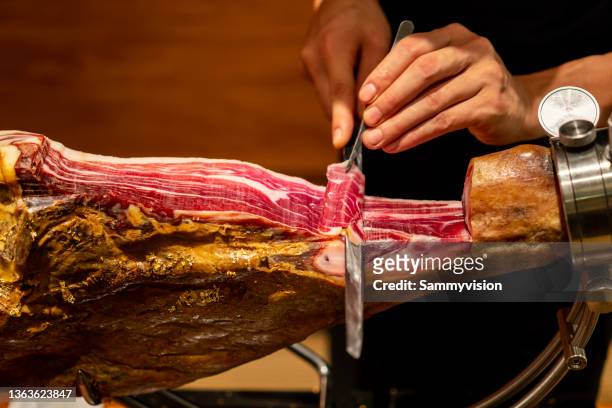 close-up of chef cutting spanish ham - lebensmittel trocknen stock-fotos und bilder