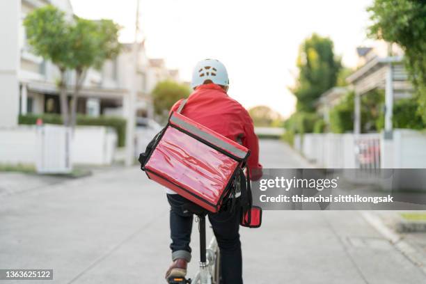 male delivery guy on bicycle with backpack in the city. - courier stockfoto's en -beelden