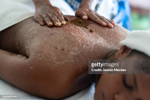 woman getting treated with mud - black massage therapist fotografías e imágenes de stock